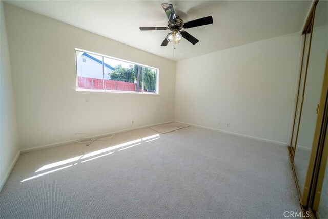 spare room featuring baseboards, a ceiling fan, and carpet flooring