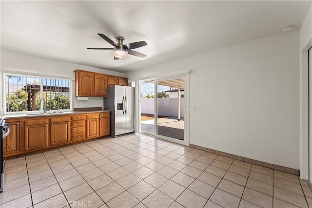 10806 Bayonne Dr, Riverside, CA 92505 - kitchen with range, stainless steel fridge, brown cabinets, ceiling fan, and a sink