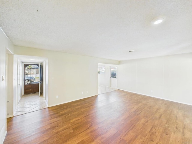 837 Oneonta St, Imperial Beach, CA 91932 - empty room with a textured ceiling, light wood-type flooring, baseboards, and a healthy amount of sunlight