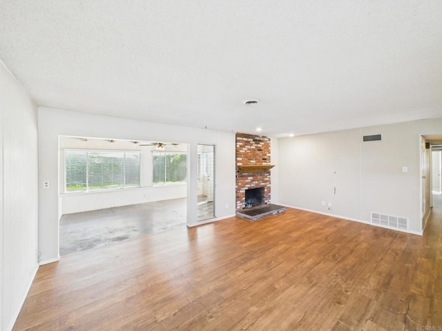 837 Oneonta St, Imperial Beach, CA 91932 - unfurnished living room featuring baseboards, wood finished floors, a fireplace, and visible vents