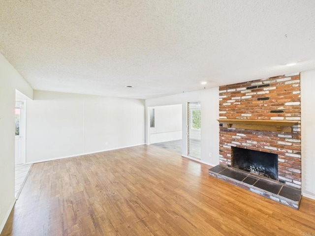 837 Oneonta St, Imperial Beach, CA 91932 - unfurnished living room with a fireplace, a textured ceiling, baseboards, and wood finished floors