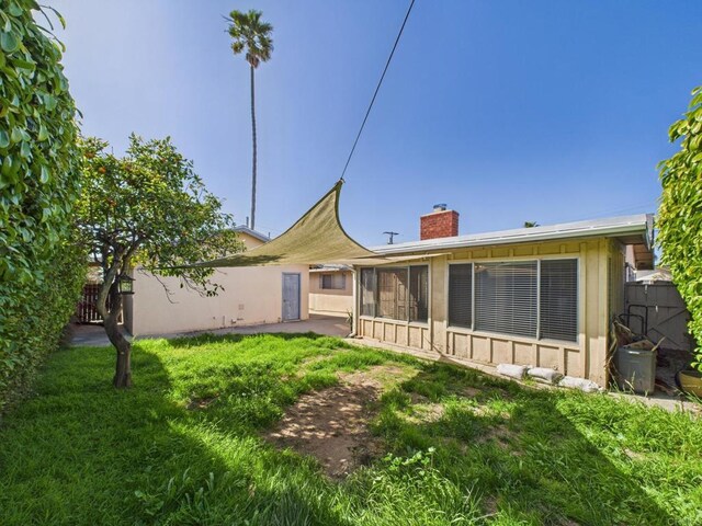 837 Oneonta St, Imperial Beach, CA 91932 - back of house featuring fence, stucco siding, a chimney, and a lawn