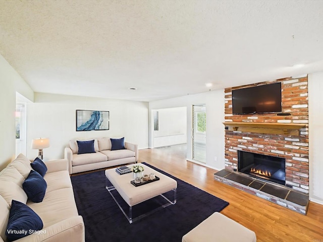 837 Oneonta St, Imperial Beach, CA 91932 - living room featuring wood finished floors, a brick fireplace, and a textured ceiling