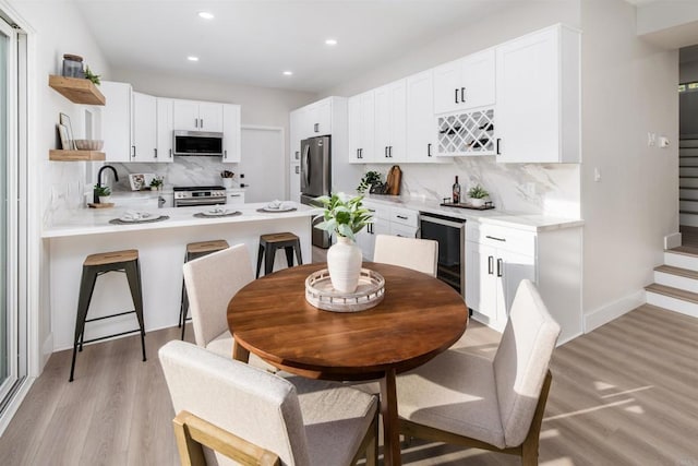 475 Parkwood Ln, Encinitas, CA 92024 - kitchen featuring stainless steel appliances, beverage cooler, open shelves, backsplash, and light wood-style floors