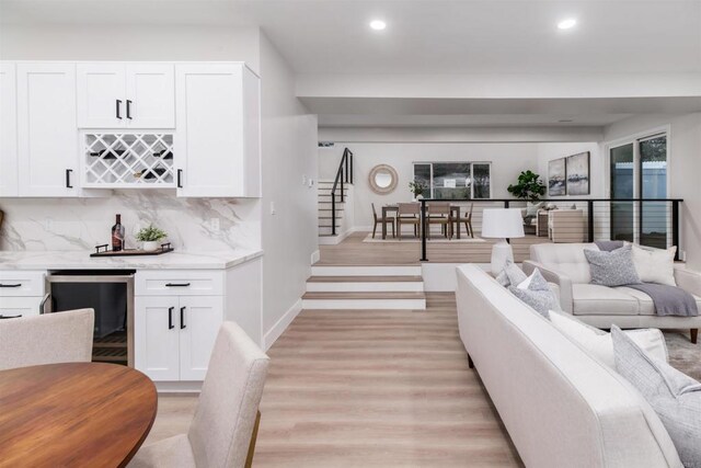 475 Parkwood Ln, Encinitas, CA 92024 - living area featuring wine cooler, recessed lighting, a bar, light wood-style flooring, and stairs