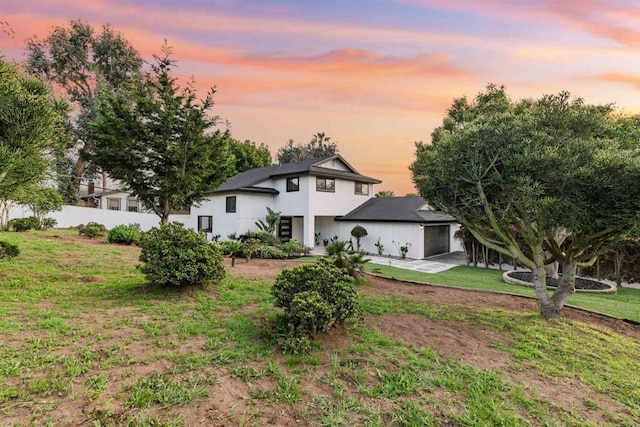 475 Parkwood Ln, Encinitas, CA 92024 - back of property at dusk featuring a garage, stucco siding, and driveway
