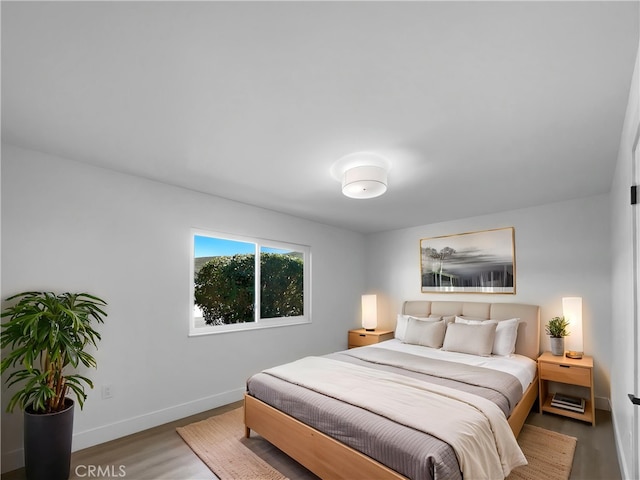 bedroom featuring wood finished floors and baseboards