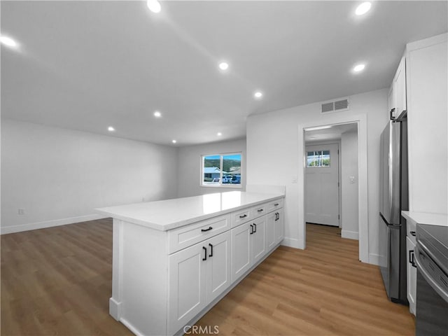 kitchen featuring a peninsula, visible vents, white cabinetry, and appliances with stainless steel finishes