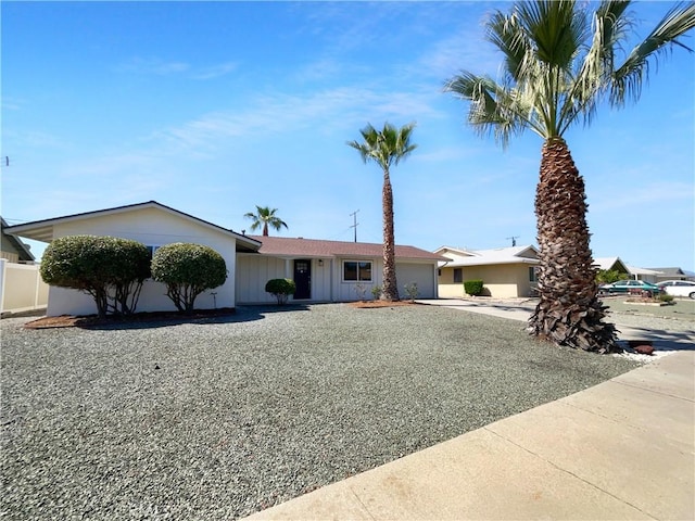 single story home featuring concrete driveway, board and batten siding, and an attached garage