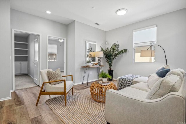 sitting room with visible vents, baseboards, and wood finished floors