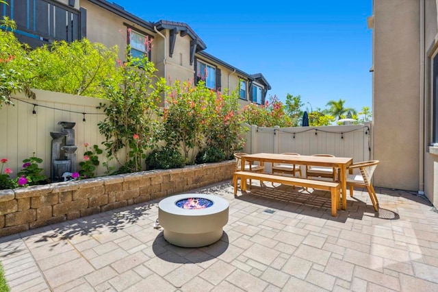 view of patio / terrace with outdoor dining space, fence, and a fire pit