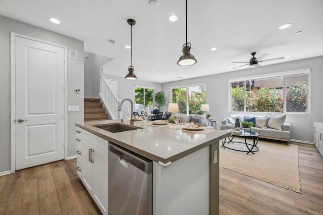 kitchen with stainless steel dishwasher, white cabinetry, recessed lighting, a sink, and open floor plan