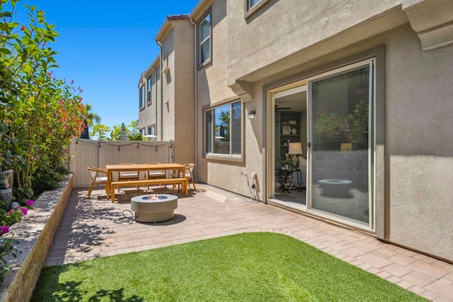 view of patio featuring an outdoor fire pit and fence