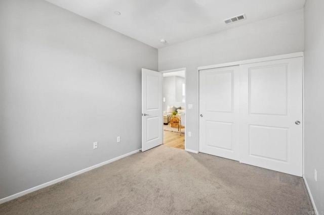 unfurnished bedroom featuring visible vents, baseboards, a closet, and carpet