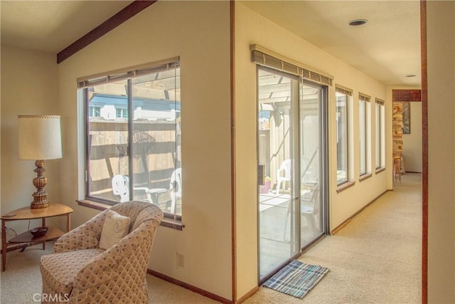entryway with lofted ceiling, light carpet, and baseboards