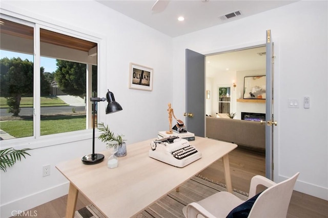 office area featuring wood finished floors, baseboards, and visible vents