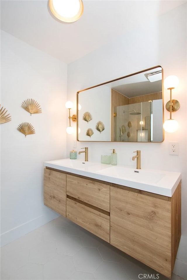 full bath with baseboards, a sink, double vanity, tile patterned flooring, and a stall shower