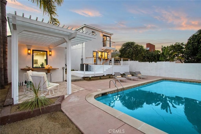 pool at dusk featuring a pergola, a fenced in pool, fence, and a patio area