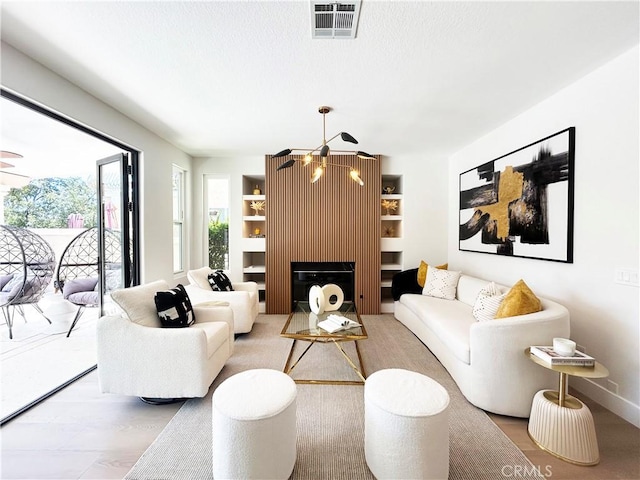 living room with visible vents, built in features, and a fireplace