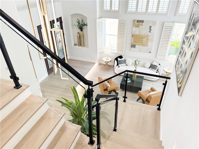 interior space featuring baseboards, arched walkways, and a high ceiling