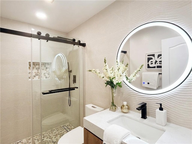 full bathroom featuring toilet, vanity, and a shower stall