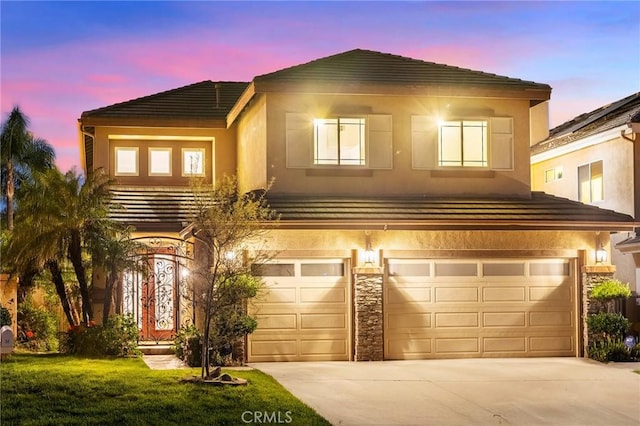 view of front of home featuring a garage, concrete driveway, and a tile roof