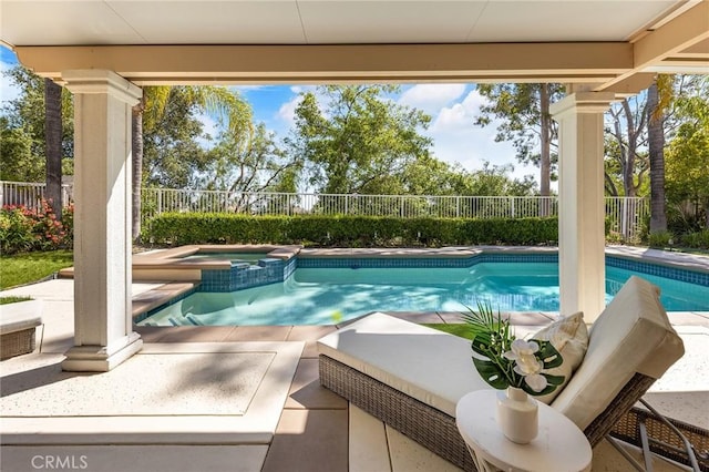view of pool with a pool with connected hot tub, a patio, and a fenced backyard