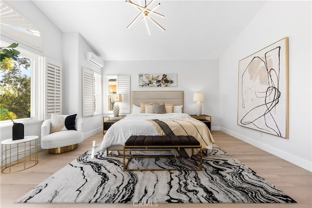 bedroom featuring baseboards, wood finished floors, and a wall unit AC