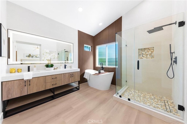 full bath featuring a soaking tub, vaulted ceiling, wood finished floors, and a shower stall