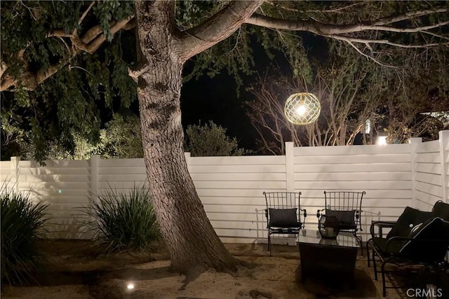 patio at night featuring fence