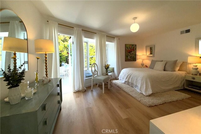 bedroom with access to outside, light wood-style flooring, and visible vents