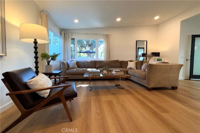 living room featuring recessed lighting, baseboards, and light wood-type flooring