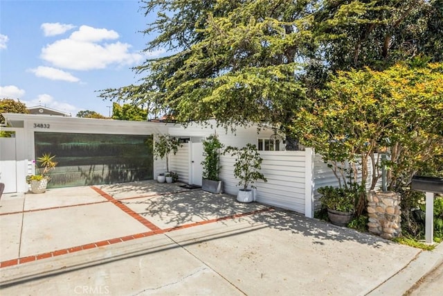 exterior space with fence and concrete driveway