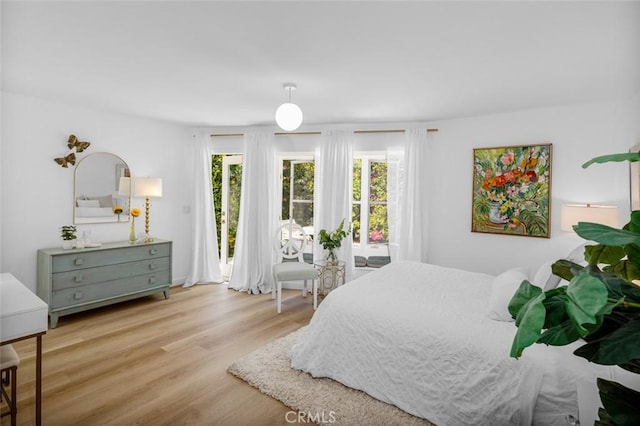 bedroom with access to exterior and wood finished floors