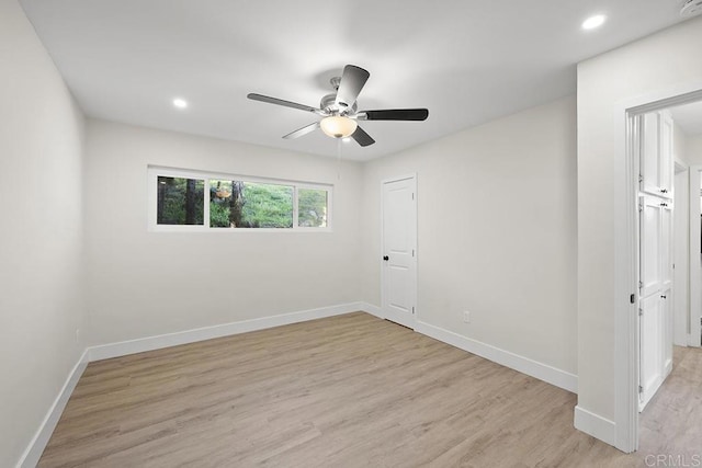 empty room with recessed lighting, ceiling fan, light wood-type flooring, and baseboards