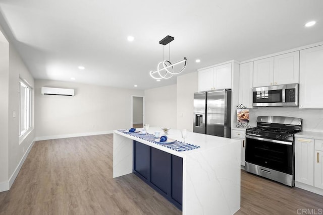 kitchen featuring a wall mounted air conditioner, recessed lighting, white cabinets, appliances with stainless steel finishes, and wood finished floors