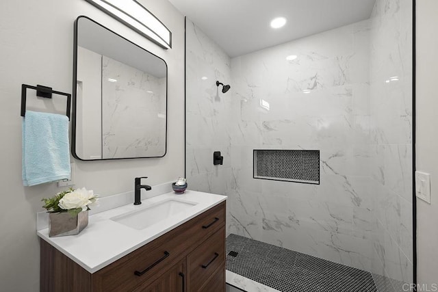 bathroom with a marble finish shower and vanity