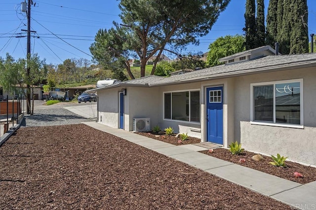view of side of property featuring stucco siding and ac unit