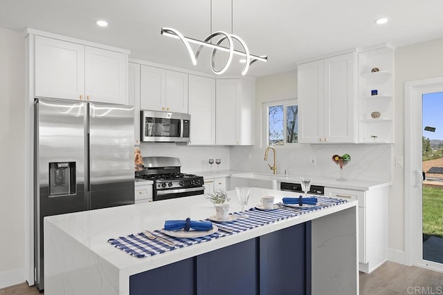 kitchen featuring open shelves, a kitchen island, white cabinets, stainless steel appliances, and a sink