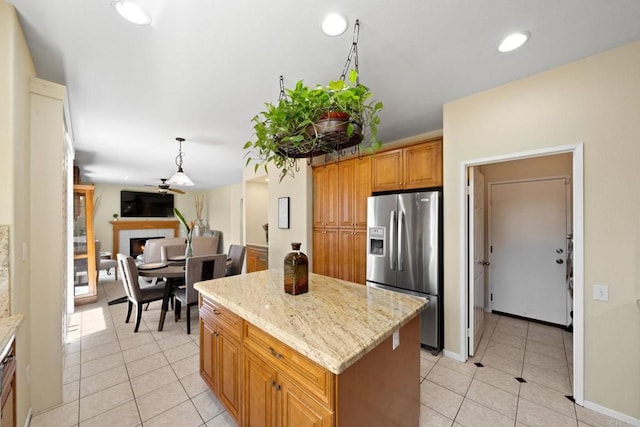1396 Carneros Valley St, Chula Vista, CA 91913 - kitchen with stainless steel fridge with ice dispenser, light tile patterned floors, a center island, light stone counters, and a ceiling fan