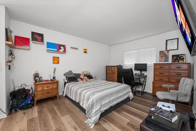 bedroom featuring baseboards and wood finished floors