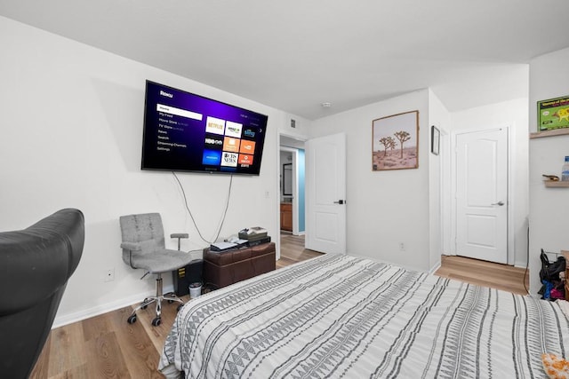 bedroom with baseboards and wood finished floors