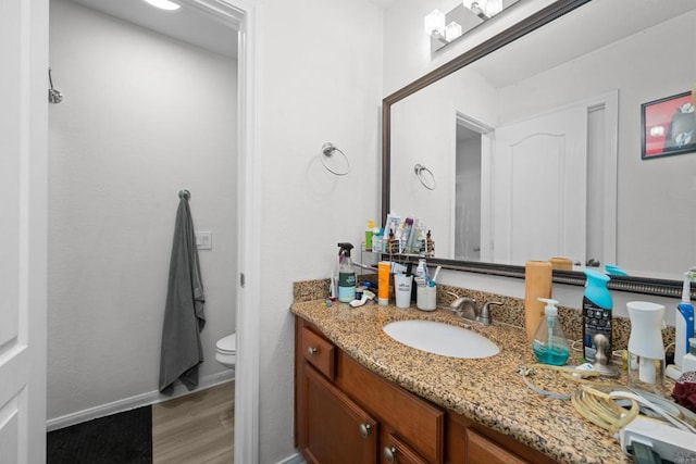 bathroom featuring vanity, toilet, and wood finished floors