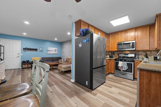 kitchen with recessed lighting, open floor plan, light wood-style flooring, and appliances with stainless steel finishes
