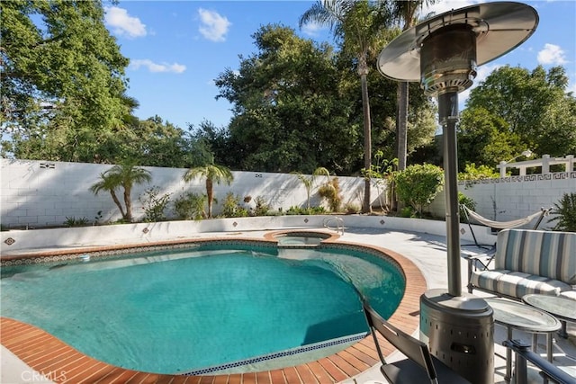 view of swimming pool featuring a fenced backyard and a pool with connected hot tub