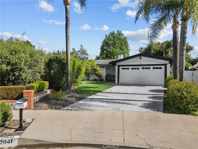 view of front facade featuring stucco siding, roof mounted solar panels, a garage, and concrete driveway