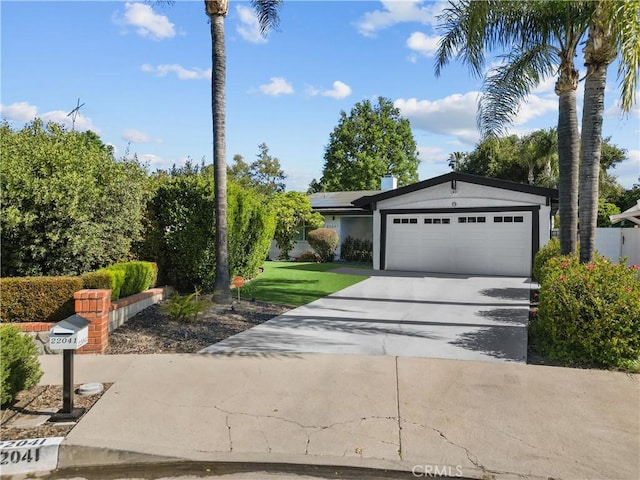 22041 Kinzie St, Chatsworth, CA 91311 - view of front of house with a garage, solar panels, and driveway