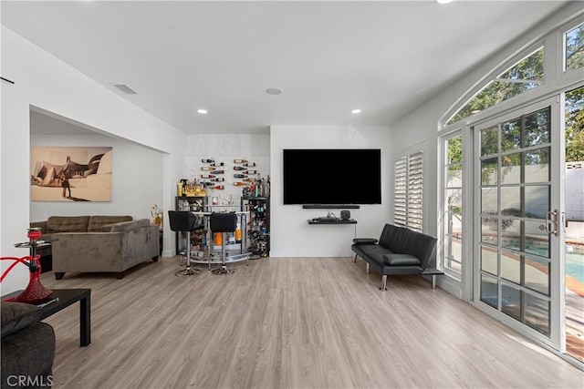 living area with recessed lighting, visible vents, and wood finished floors