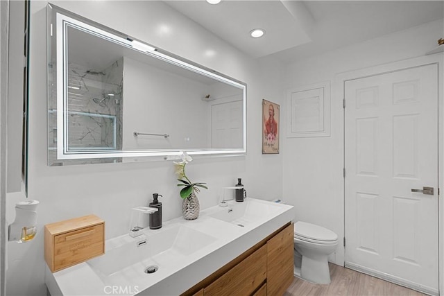 22041 Kinzie St, Chatsworth, CA 91311 - bathroom featuring toilet, double vanity, wood finished floors, a shower, and recessed lighting