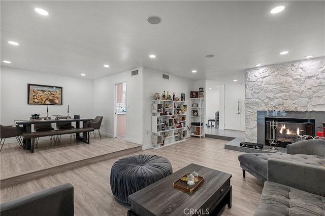 22041 Kinzie St, Chatsworth, CA 91311 - living area featuring light wood-type flooring, a stone fireplace, and recessed lighting